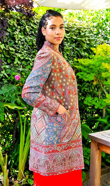 Paisley-dapple cashmere-silk jacket in browns, pinks and turquoise, nehru collar, handwoven, fully lined, Nelly in garden side view, pockets